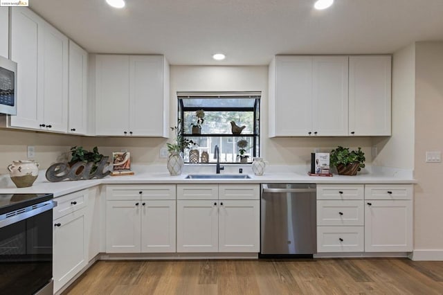 kitchen featuring white cabinetry, sink, light wood-type flooring, and appliances with stainless steel finishes