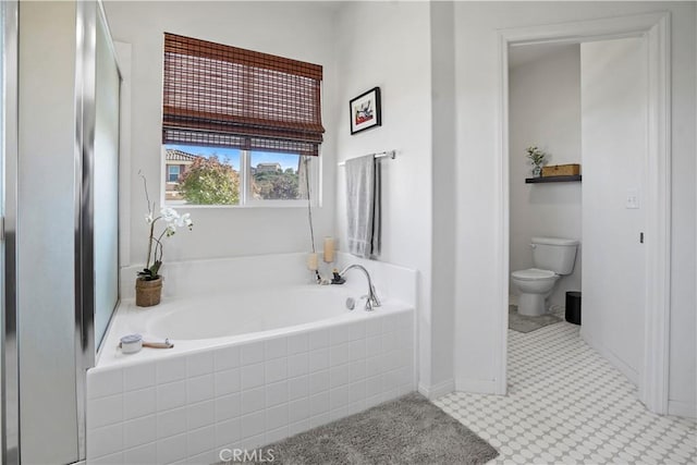 bathroom featuring toilet and tiled tub