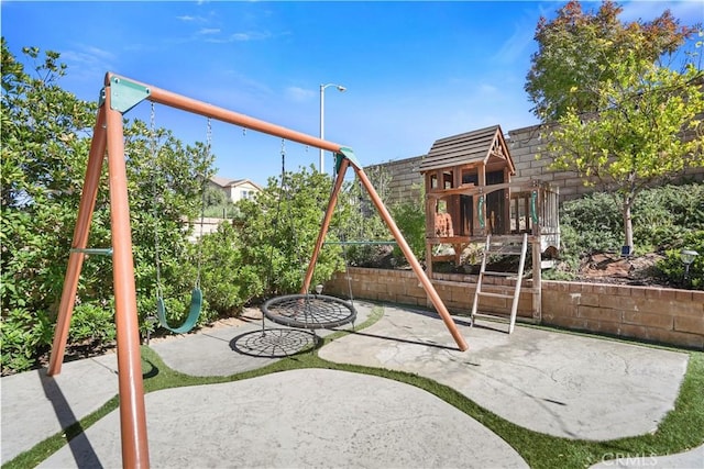 view of playground featuring a patio