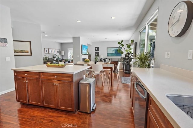 kitchen featuring dishwasher, a center island, sink, and dark wood-type flooring