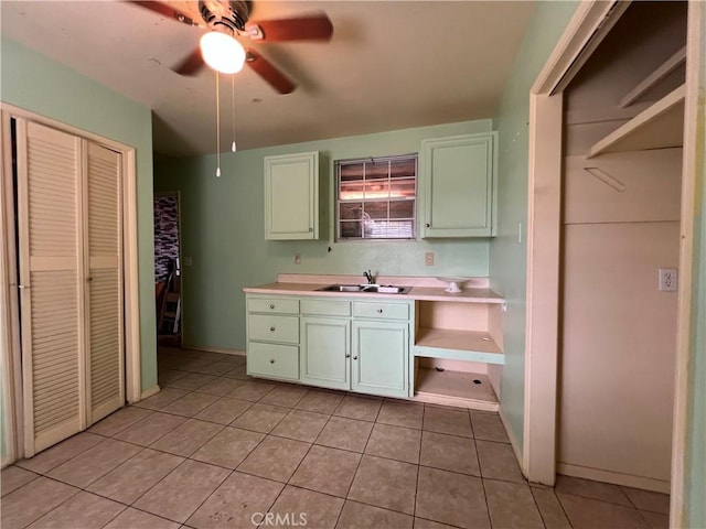 kitchen with light tile patterned floors, ceiling fan, and sink