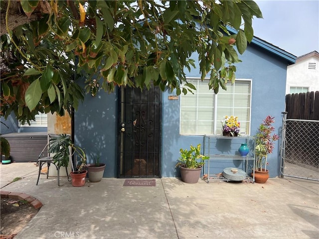 view of exterior entry with a patio