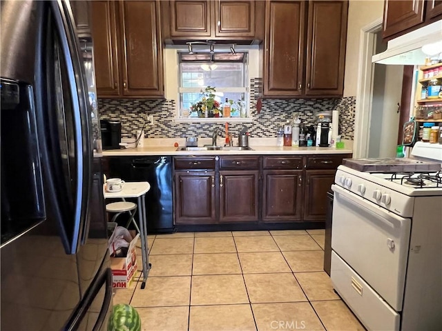 kitchen with black appliances, light tile patterned floors, sink, and tasteful backsplash