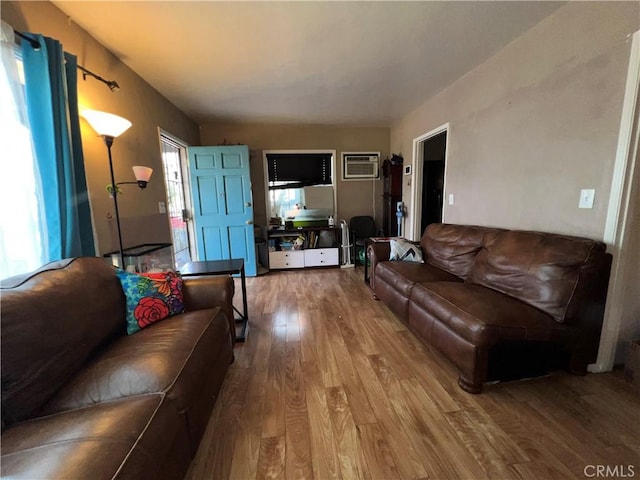 living room featuring an AC wall unit and hardwood / wood-style floors