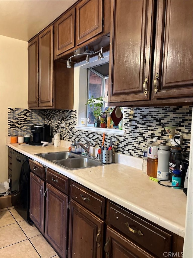 kitchen with tasteful backsplash, sink, dark brown cabinets, and black dishwasher