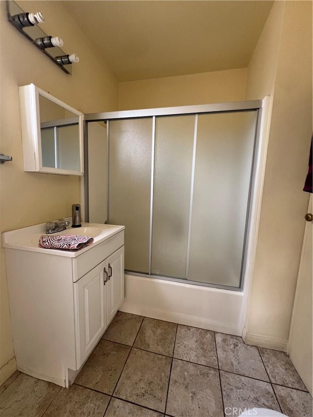 bathroom featuring tile patterned flooring, vanity, and enclosed tub / shower combo