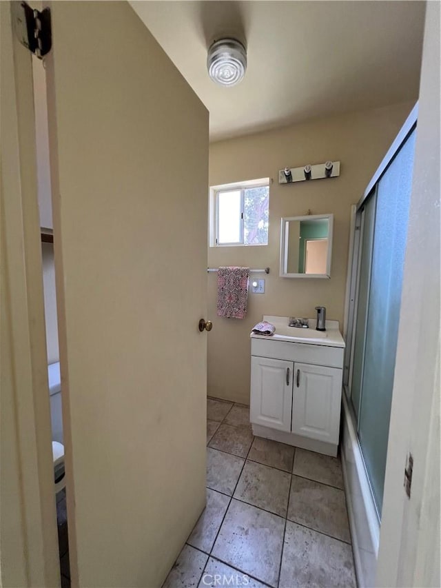 bathroom with tile patterned flooring, vanity, shower / bath combination with glass door, and lofted ceiling