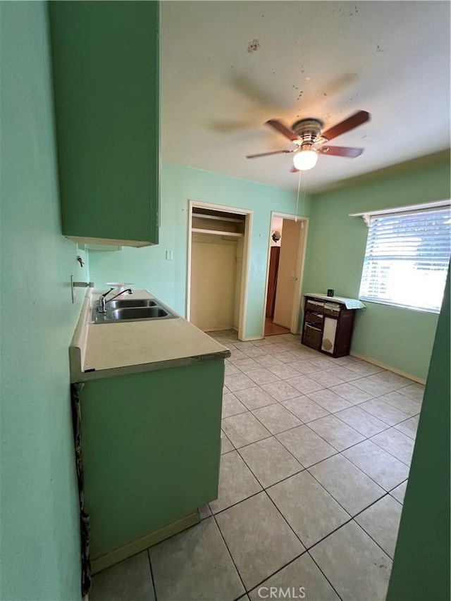 kitchen featuring ceiling fan, light tile patterned floors, sink, and green cabinetry