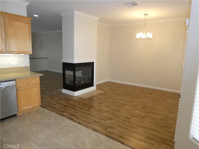 kitchen with dishwasher, a multi sided fireplace, backsplash, light brown cabinetry, and light wood-type flooring