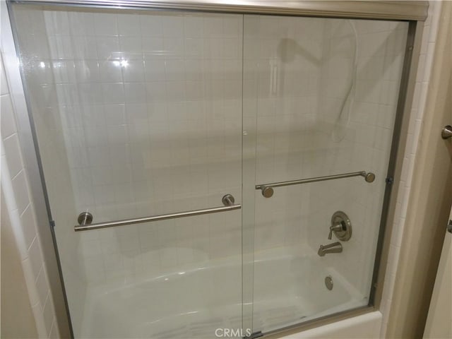 bathroom with shower / bath combination with glass door