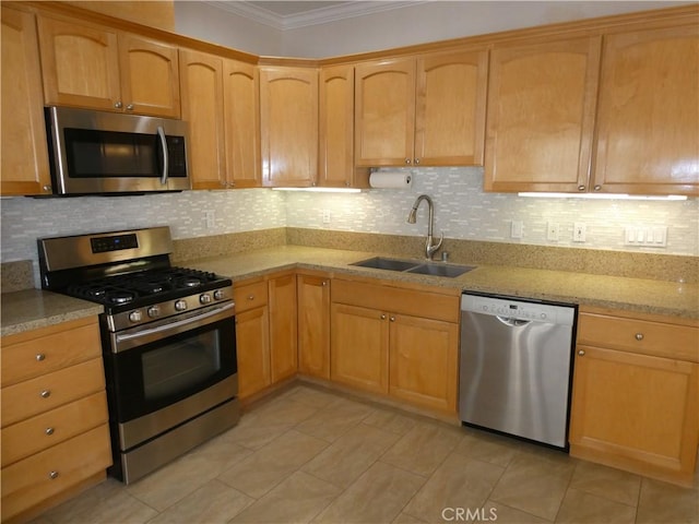 kitchen featuring appliances with stainless steel finishes, backsplash, light stone counters, crown molding, and sink