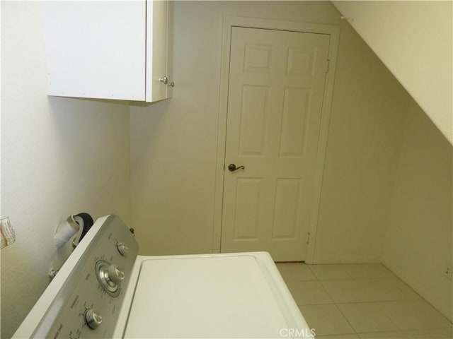 laundry area featuring cabinets, light tile patterned floors, and washer / clothes dryer