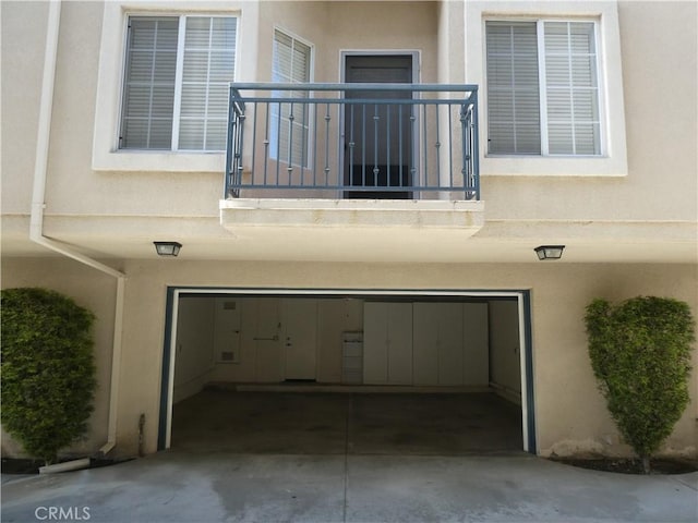 view of exterior entry featuring a balcony and a garage