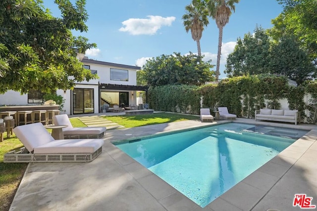 view of swimming pool featuring a patio area and exterior bar