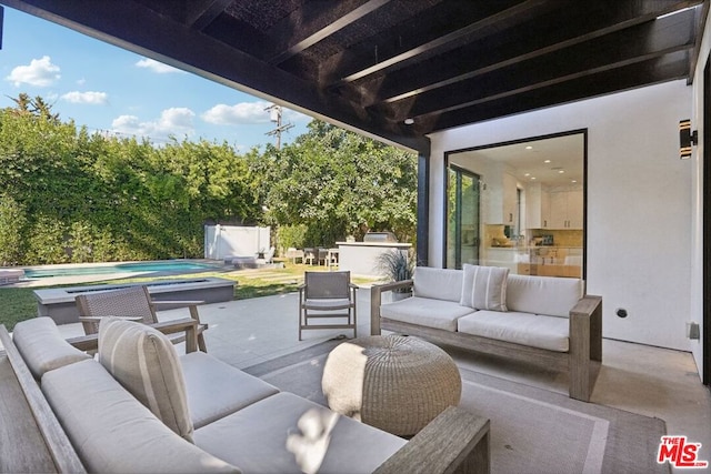 view of patio / terrace with an outdoor living space, exterior kitchen, and a storage shed