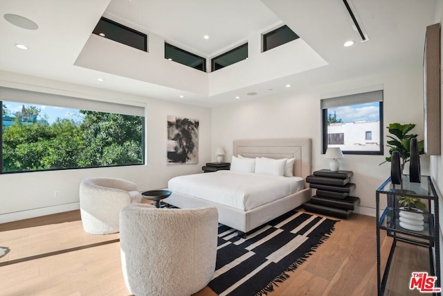 bedroom featuring multiple windows and light hardwood / wood-style flooring