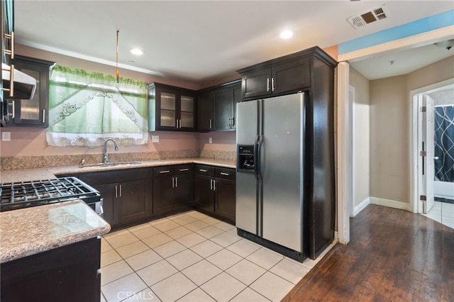 kitchen featuring pendant lighting, light wood-type flooring, sink, and appliances with stainless steel finishes