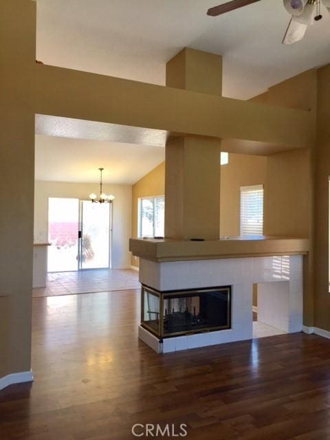 unfurnished living room with lofted ceiling, a healthy amount of sunlight, and wood-type flooring