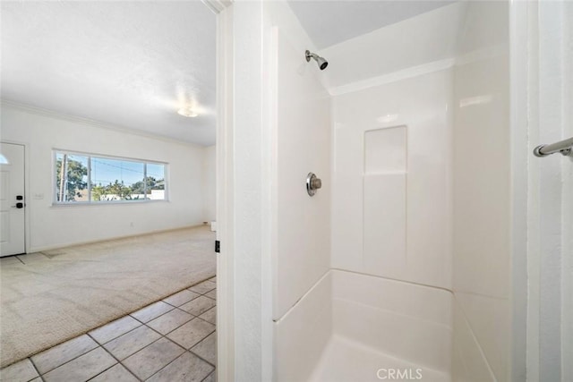 bathroom featuring a shower, tile patterned floors, and crown molding