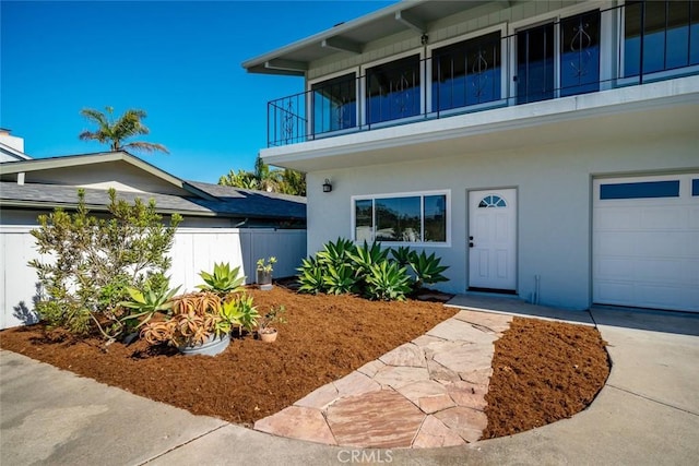 view of front of property featuring a garage and a balcony