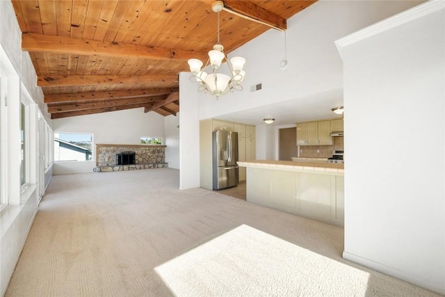 unfurnished living room with light carpet, a fireplace, a notable chandelier, beam ceiling, and wood ceiling