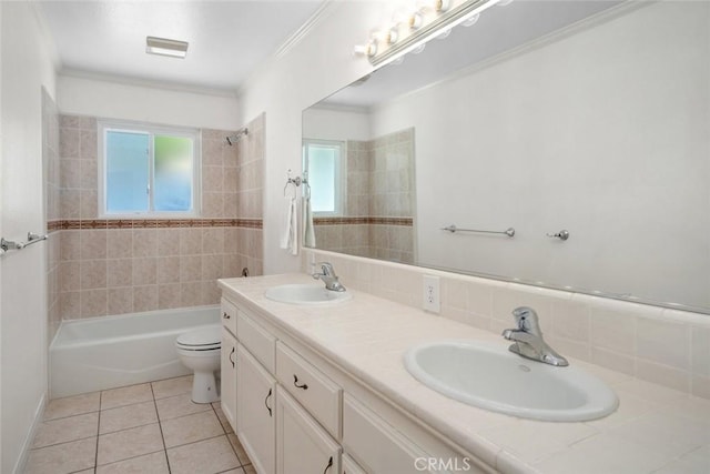 full bathroom featuring vanity, tile patterned floors, crown molding, tiled shower / bath combo, and toilet