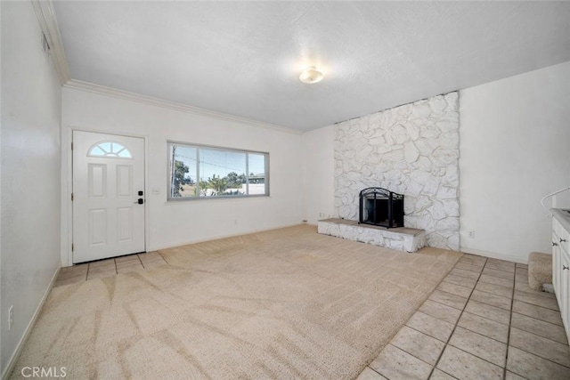 unfurnished living room with a stone fireplace, light carpet, and crown molding