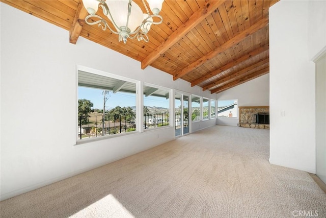 interior space featuring lofted ceiling with beams, a fireplace, a chandelier, and wooden ceiling