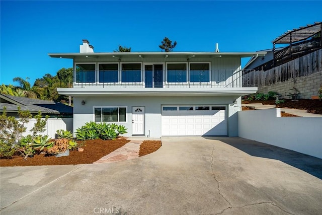 view of front of property featuring a garage and a balcony