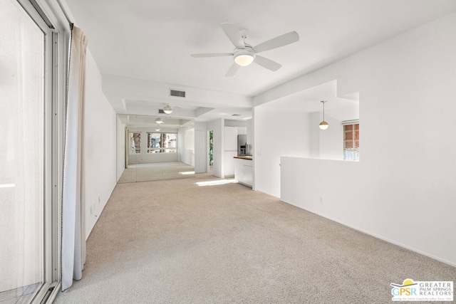 unfurnished living room with ceiling fan and light carpet