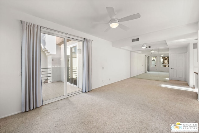 empty room featuring ceiling fan and light colored carpet