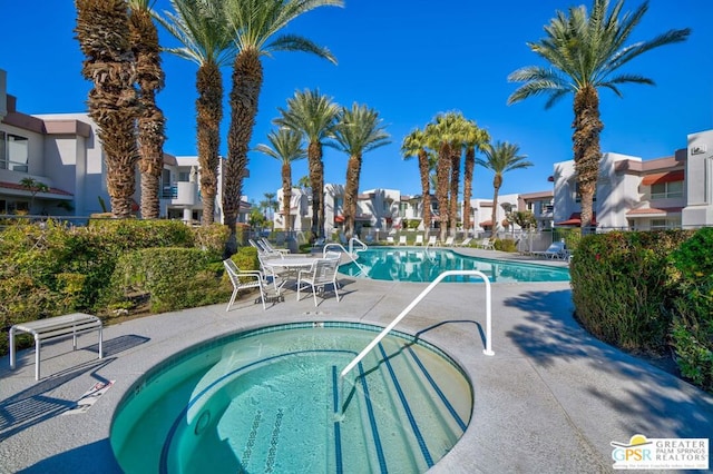 view of swimming pool with a hot tub and a patio