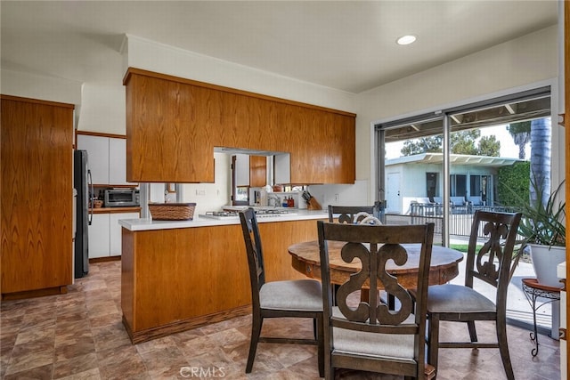 4614 La Subida Pl, Tarzana, CA 91356 - kitchen featuring brown cabinetry, stainless steel appliances, a peninsula, light countertops, and recessed lighting