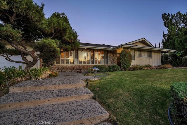 ranch-style home featuring a lawn