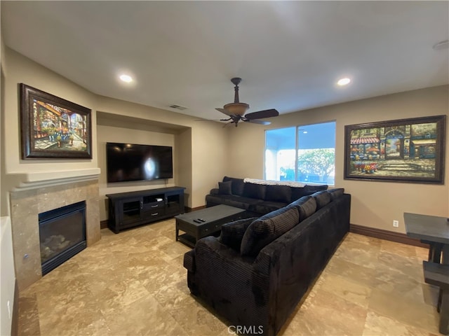 living room with a premium fireplace and ceiling fan