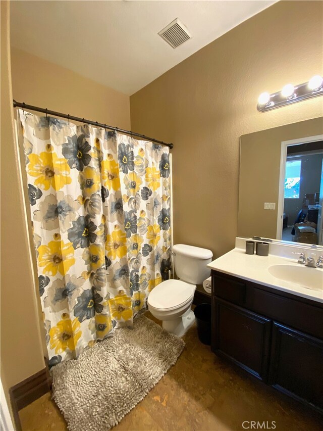 bathroom featuring vanity, curtained shower, and toilet