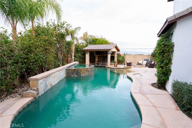 view of pool featuring an in ground hot tub and a patio