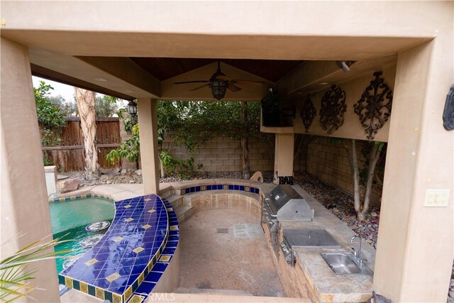 view of pool featuring ceiling fan, sink, a patio area, and exterior kitchen