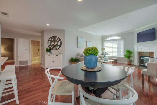 dining space featuring wood-type flooring and ornamental molding