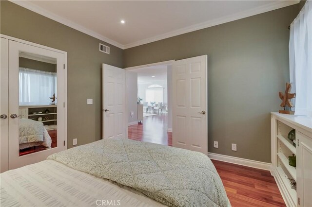 bedroom with crown molding and hardwood / wood-style floors