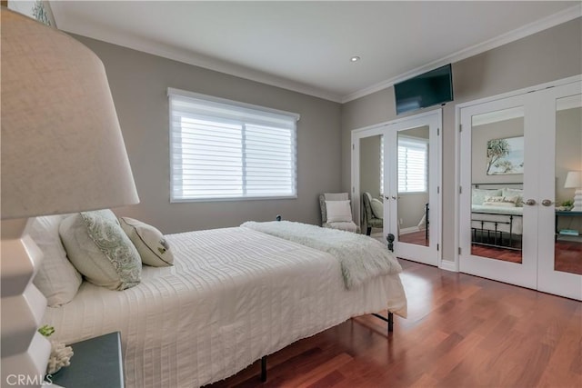 bedroom with french doors, crown molding, and hardwood / wood-style flooring