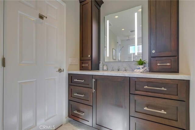 bathroom featuring walk in shower and vanity