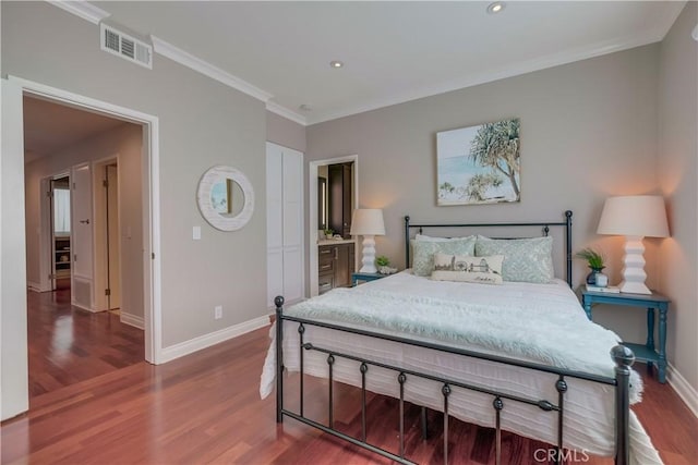 bedroom featuring ensuite bathroom, ornamental molding, and hardwood / wood-style floors