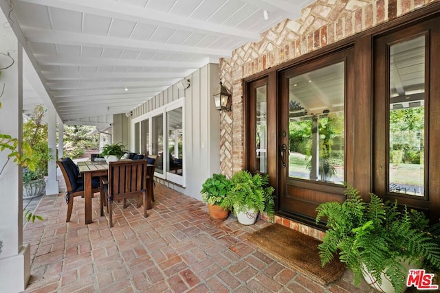 sunroom with vaulted ceiling with beams