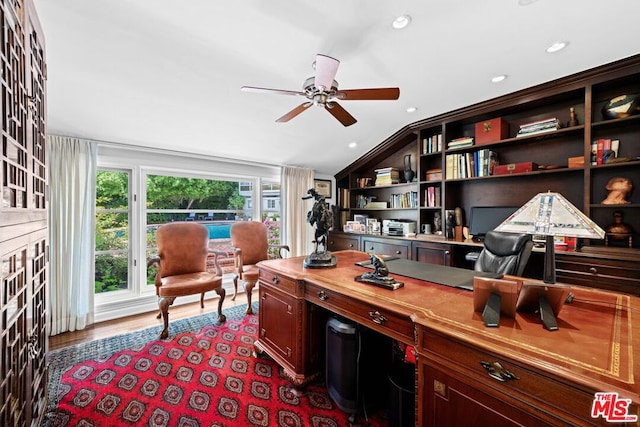 home office featuring lofted ceiling, plenty of natural light, hardwood / wood-style floors, and ceiling fan