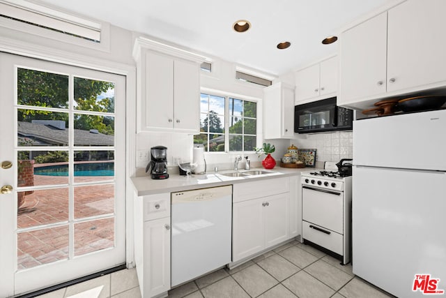 kitchen featuring sink, white cabinetry, tasteful backsplash, light tile patterned floors, and white appliances