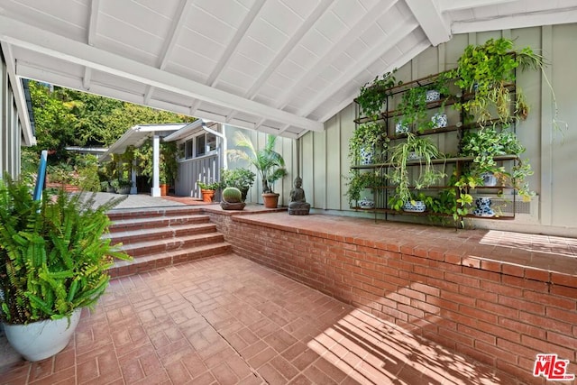 unfurnished sunroom with vaulted ceiling with beams