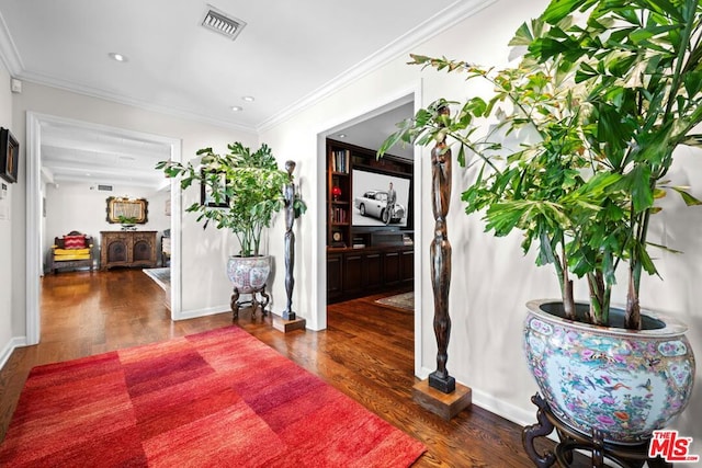 hall with dark wood-type flooring and crown molding