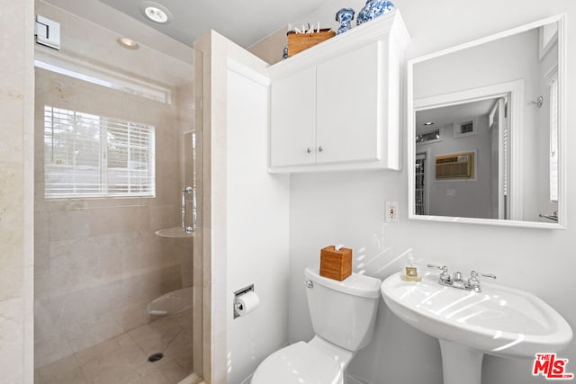 bathroom featuring sink, an enclosed shower, and toilet