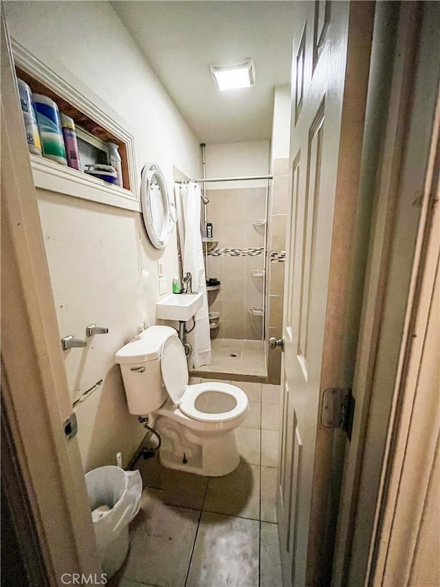 bathroom featuring walk in shower, sink, tile patterned flooring, and toilet